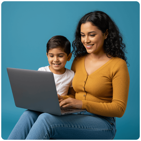 Madre con su hijo sonrientes viendo la pantalla de un laptop